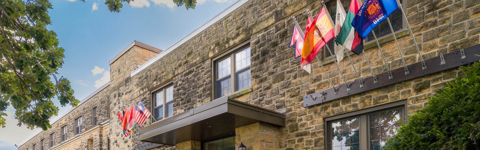Flags of various countries and the Wisconsin state flag flying on Kronshage Residence Hall