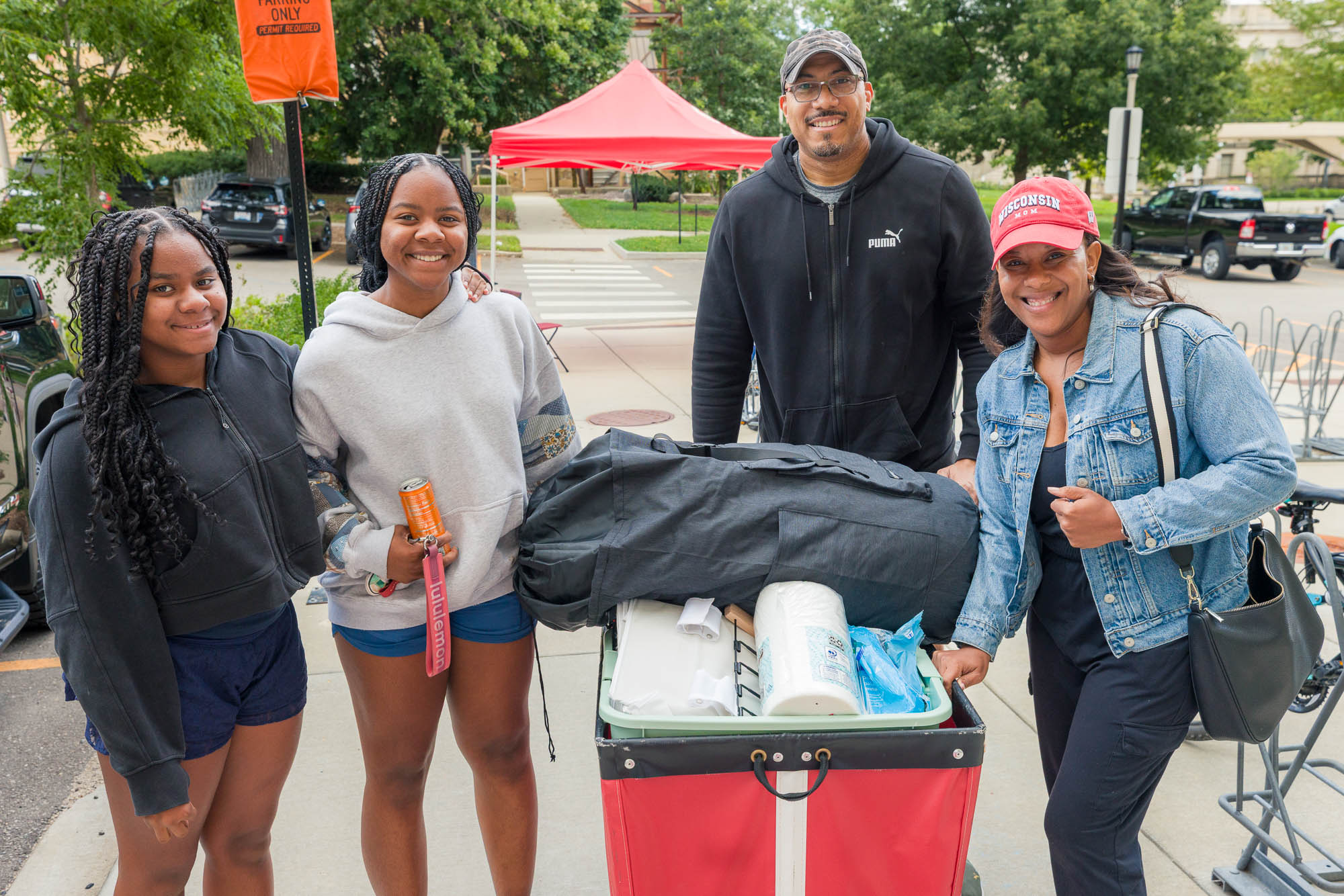 Four people posing for a photo with a moving cart