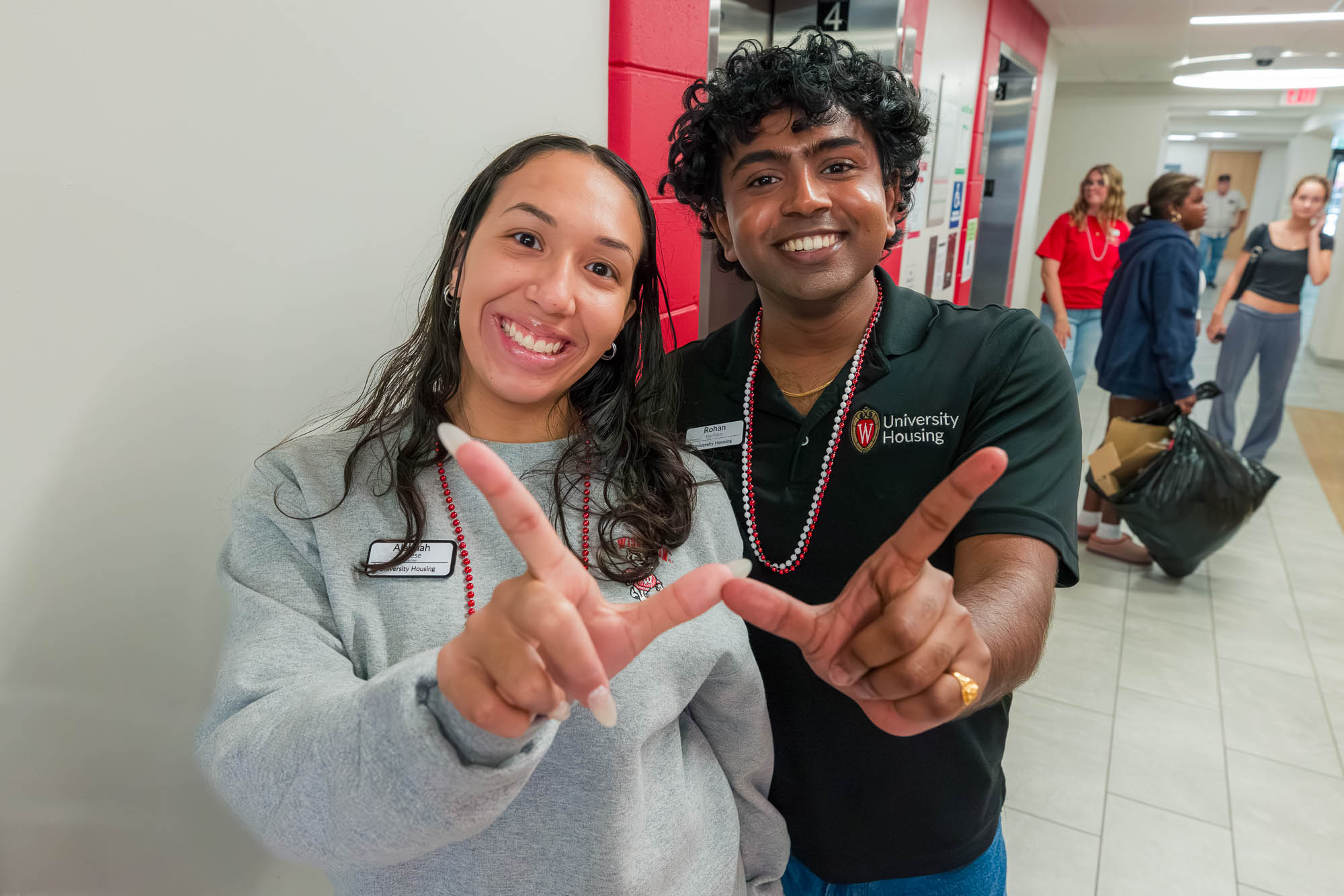 Two people pose for a photo while making a "W" with their hands