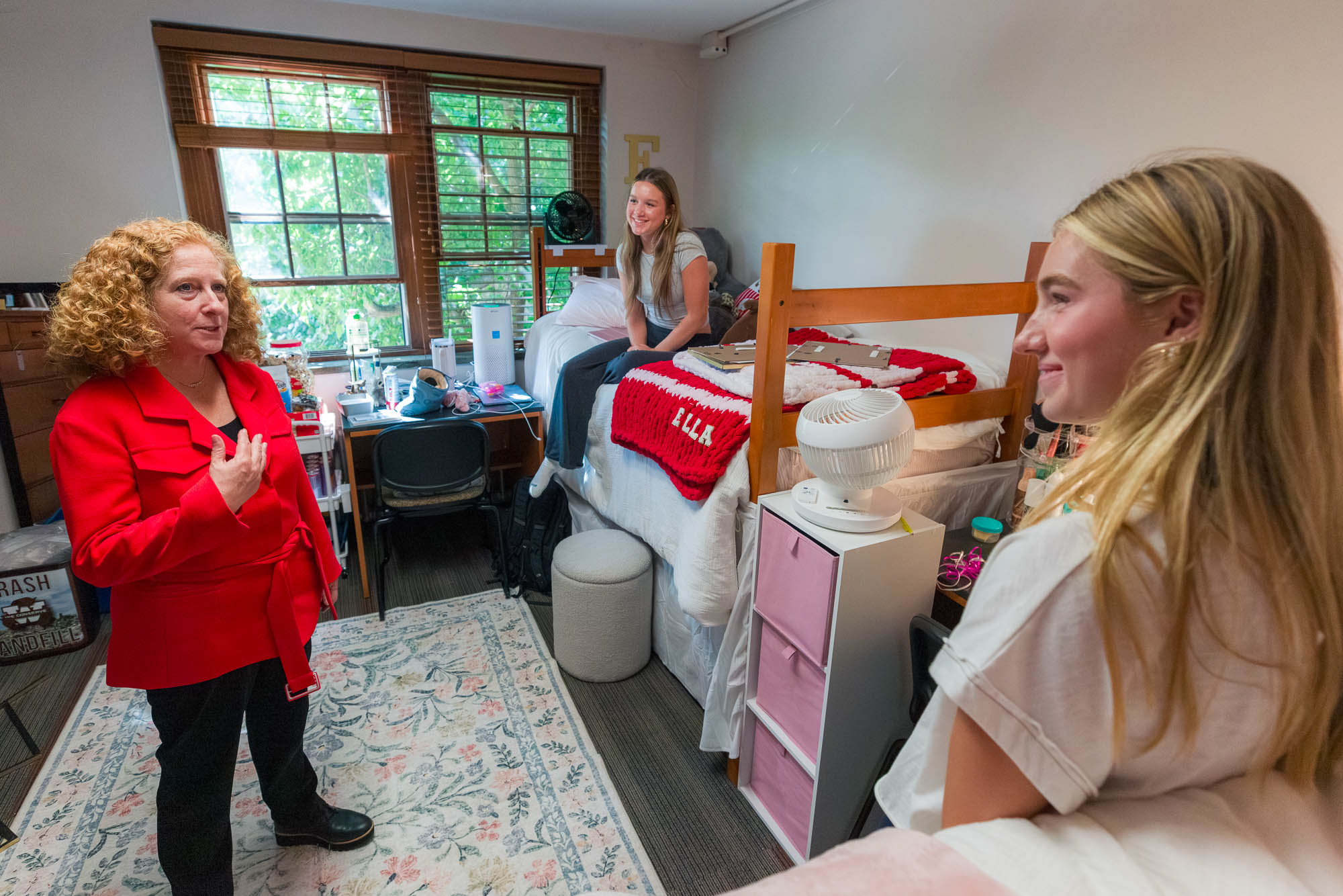 Three people talking inside a residence hall room