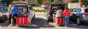 Groups of people unloading vehicles during move-in