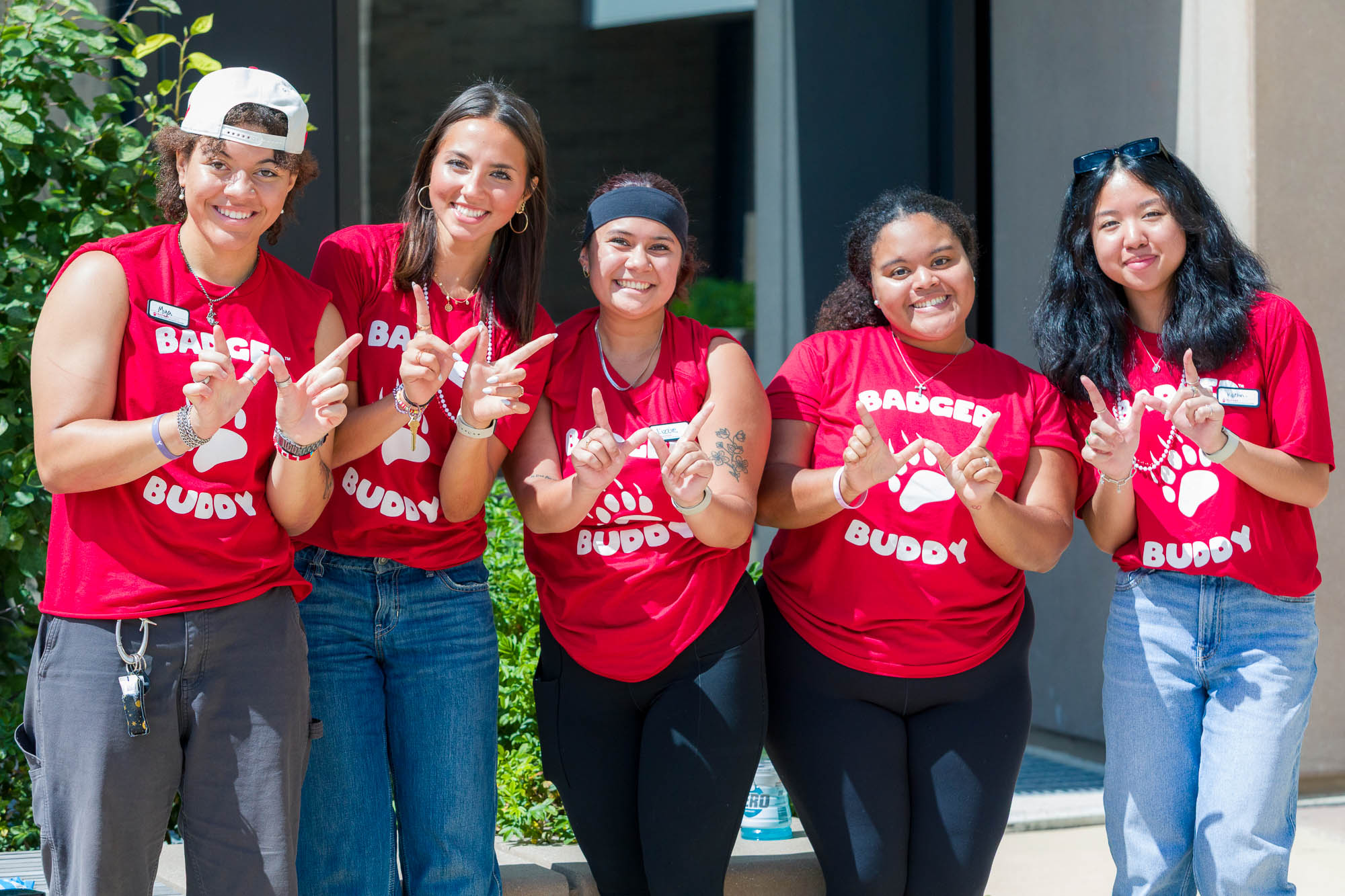 Five people pose for a photo while making "W's" with their hands