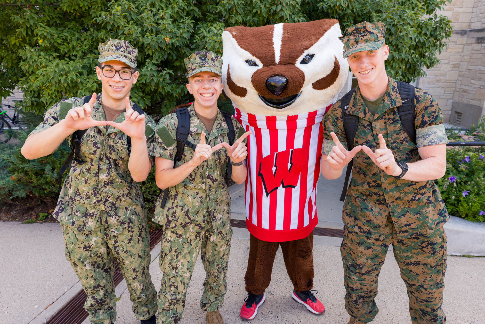 Three people in military fatigues and hats with Bucky