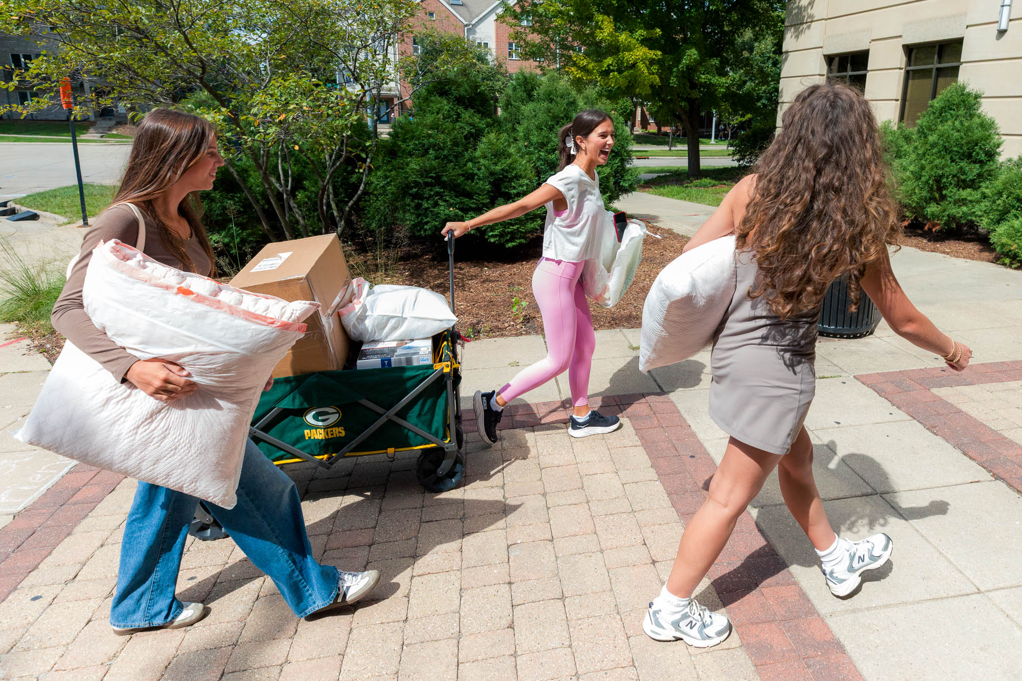 Three people walking with a moving cart