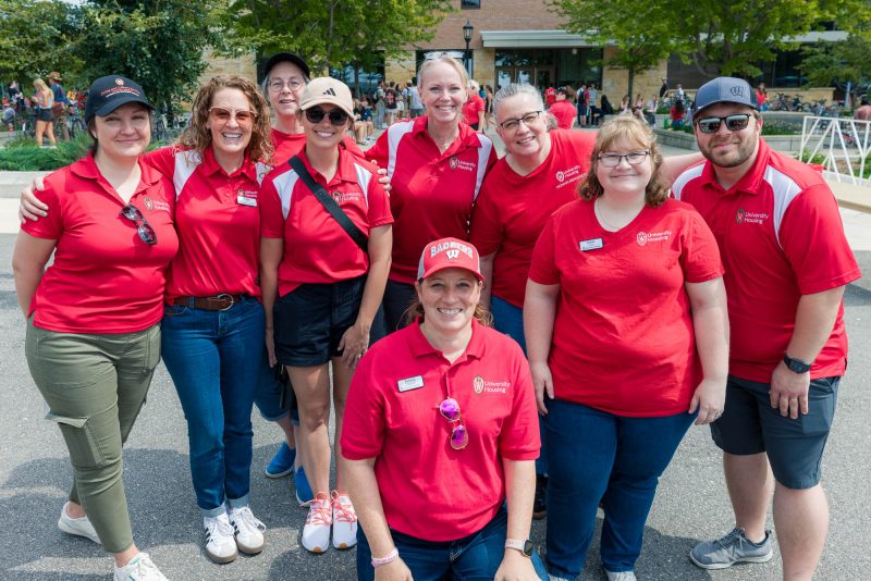 A group of people in red University Housing staff shirts posing for a photo