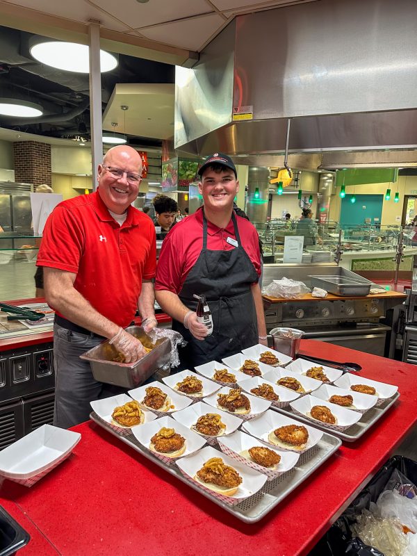 Hormel Rep and a student worker pose for a photo with the special Hormel sandwiches