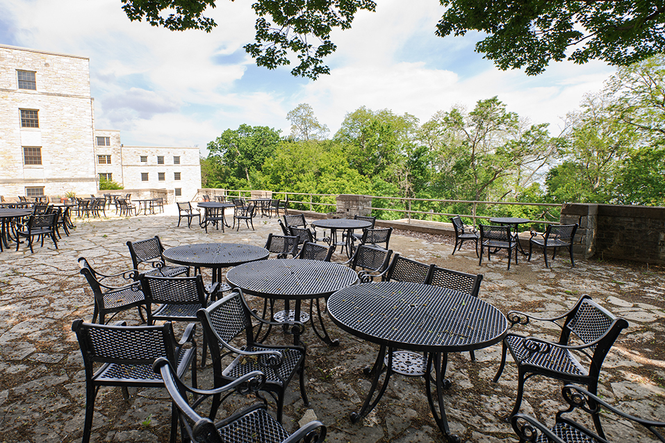 empty tables outside Waters Hall in the summer