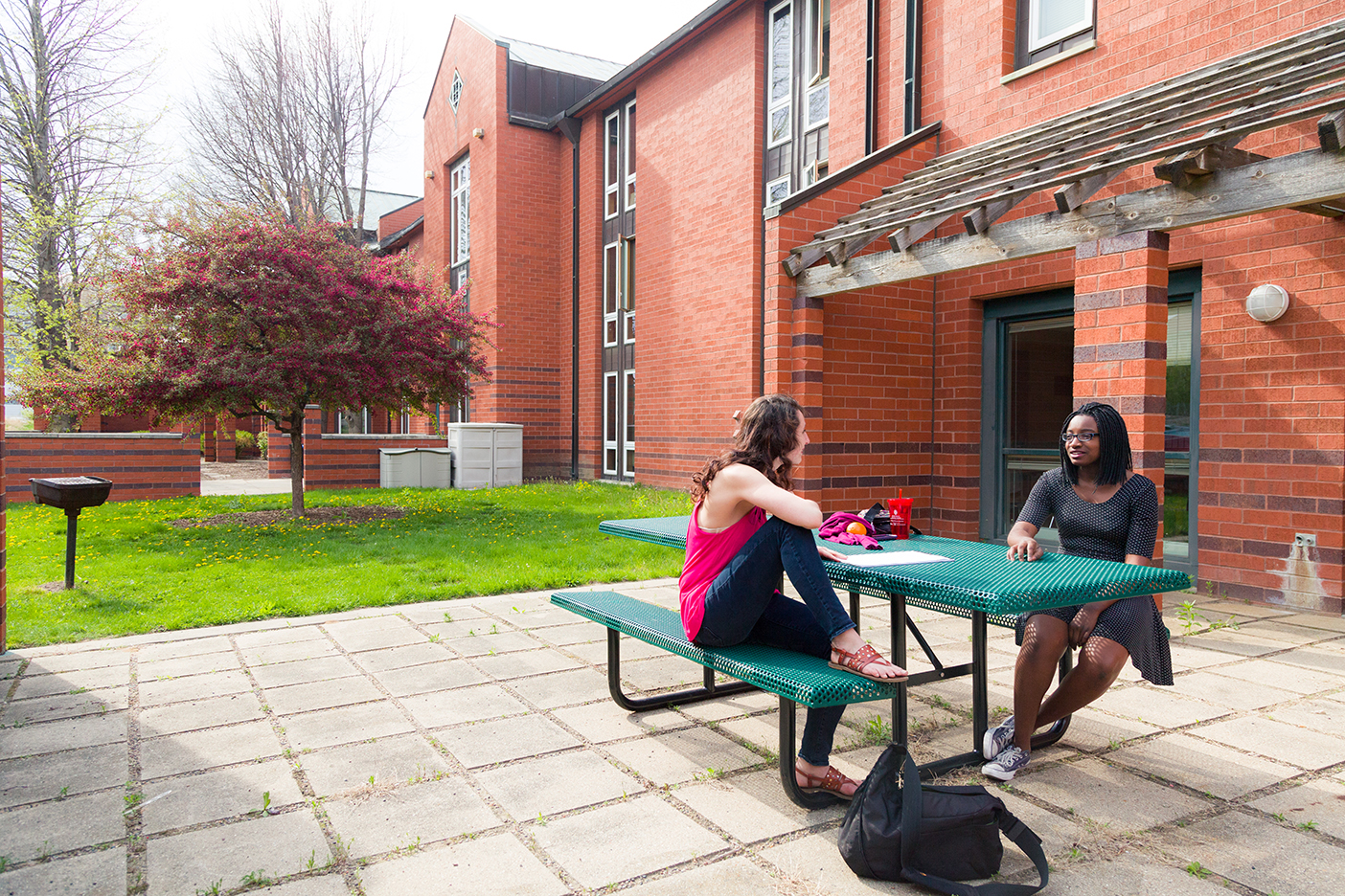 students at picnic tables outside of Merit Hall