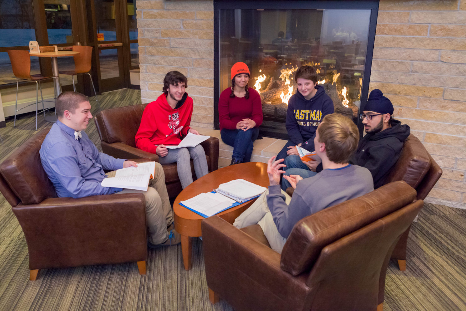 Open House residents spend time together in front of the fireplace in Dejope Hall