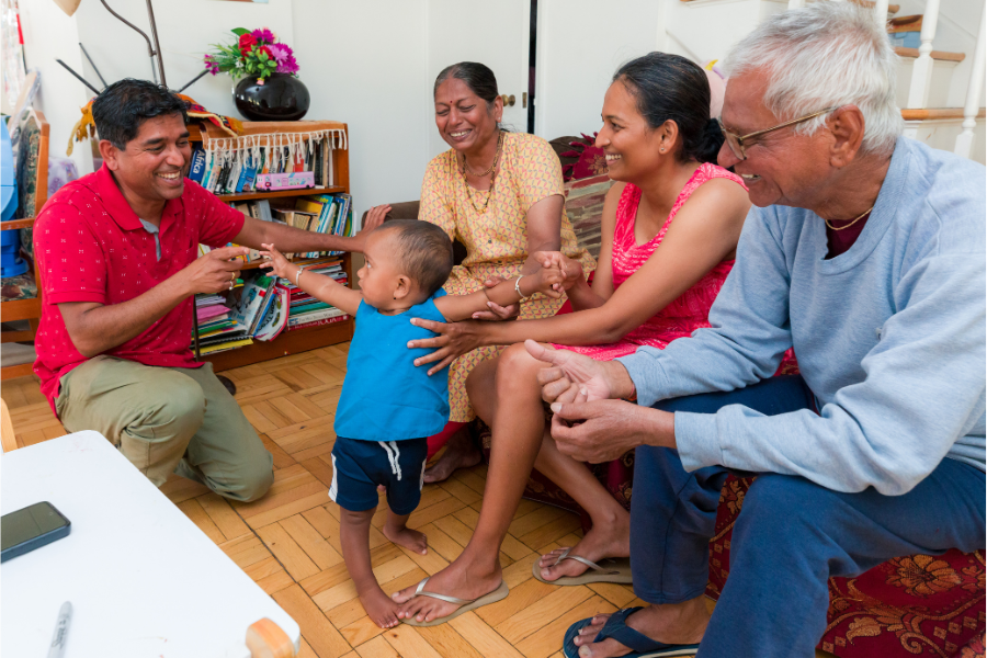 A family laughs at their toddler in an Eagle Heights Apartment.