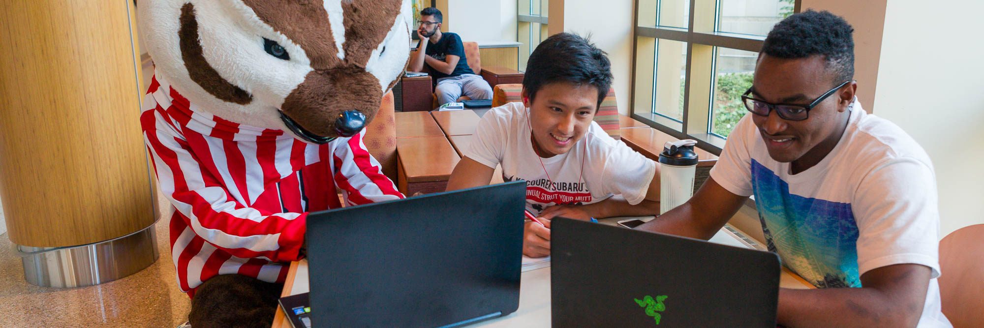 Bucky works on a computer with some other students