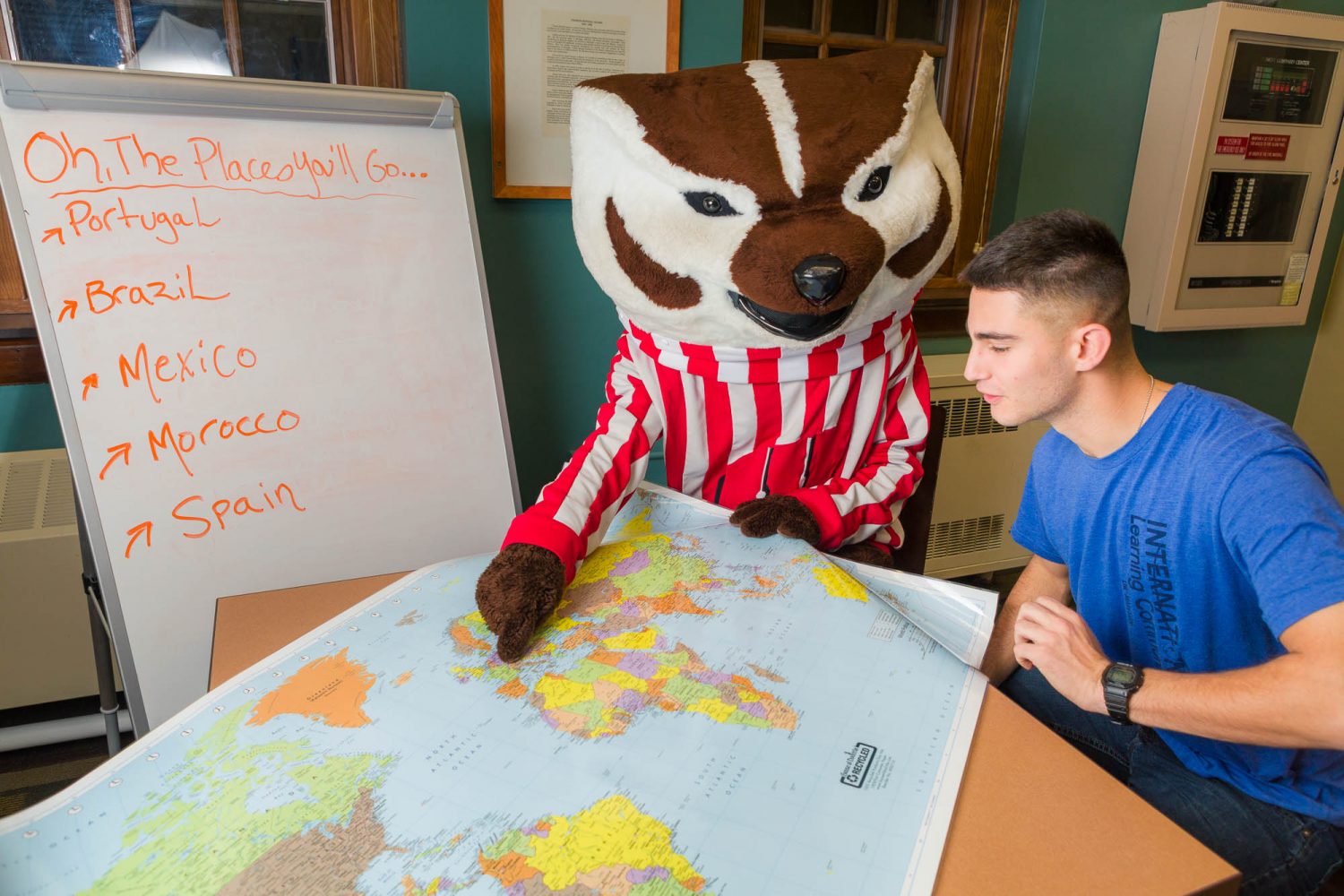 Bucky with a student pointing at a world map