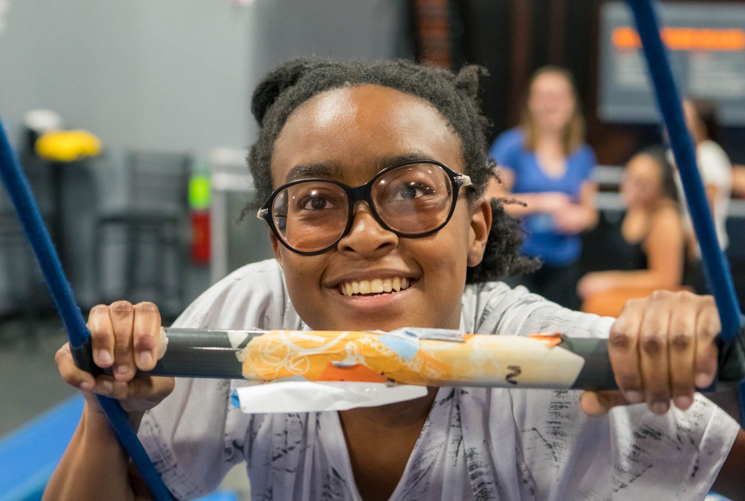 An MLC student climbs a ladder during an event at a trampoline park