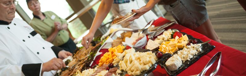 Reception buffet with guests and catering chef.