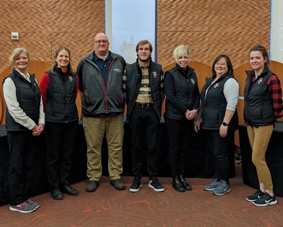 Seven Dining staff in matching vests pose for a group photo at Gordon