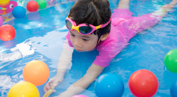 A young child playing in a shallow pool