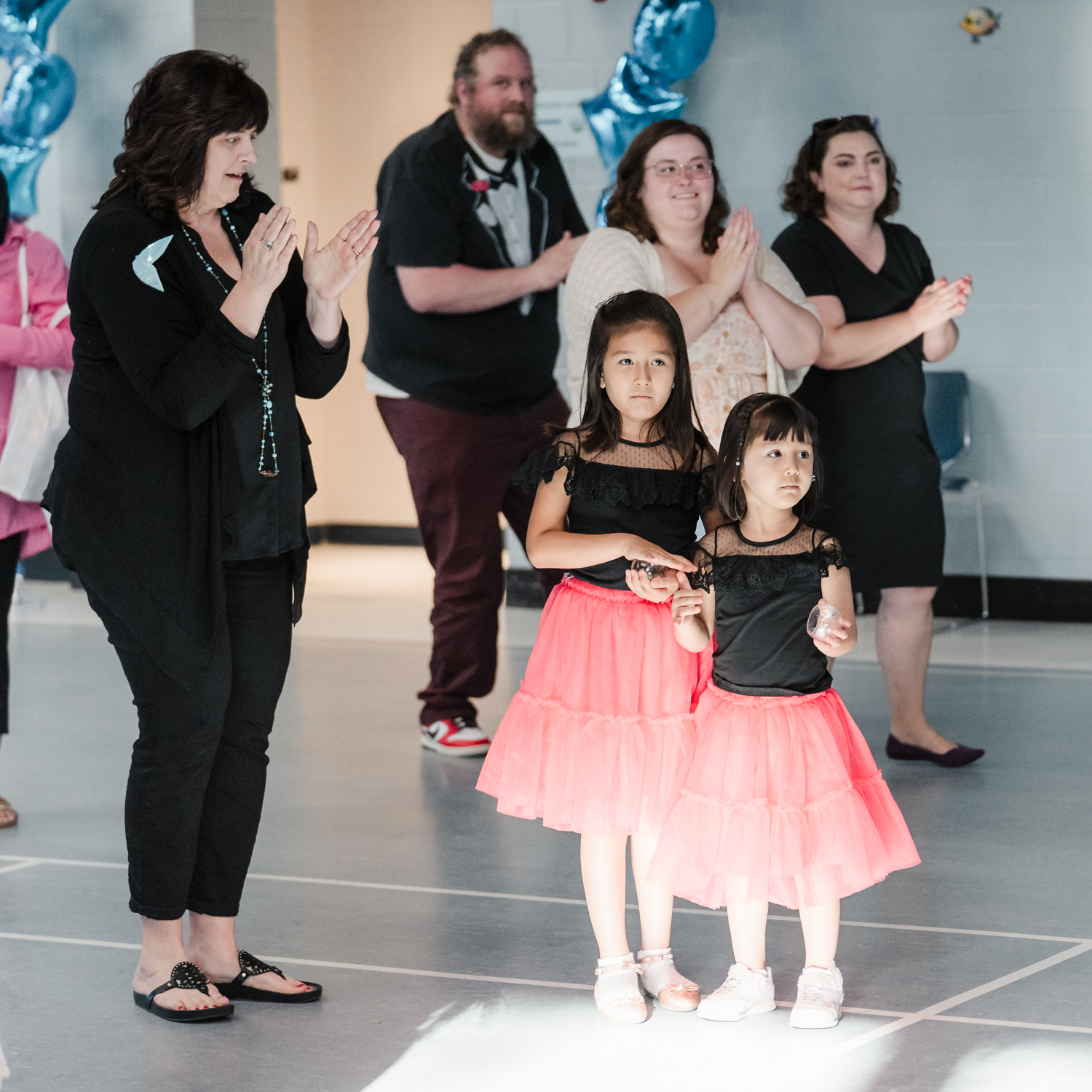 Four adults clapping and two children dancing