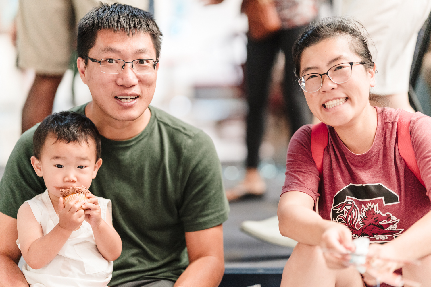 Two adults and a young child taking a group photo