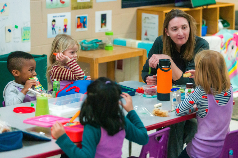 Eagle's Wing teacher sitting for snack with students
