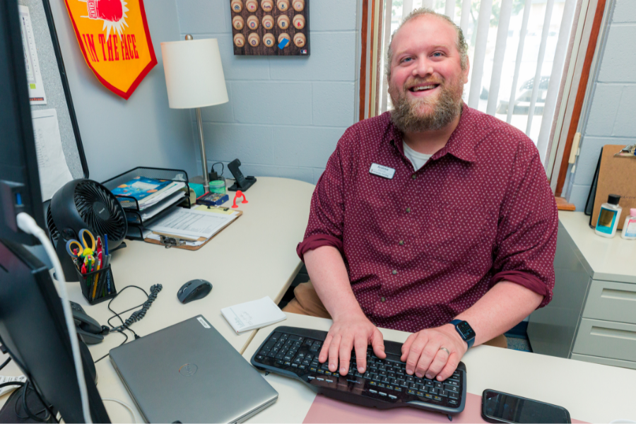 Andrew at US smiling in his office