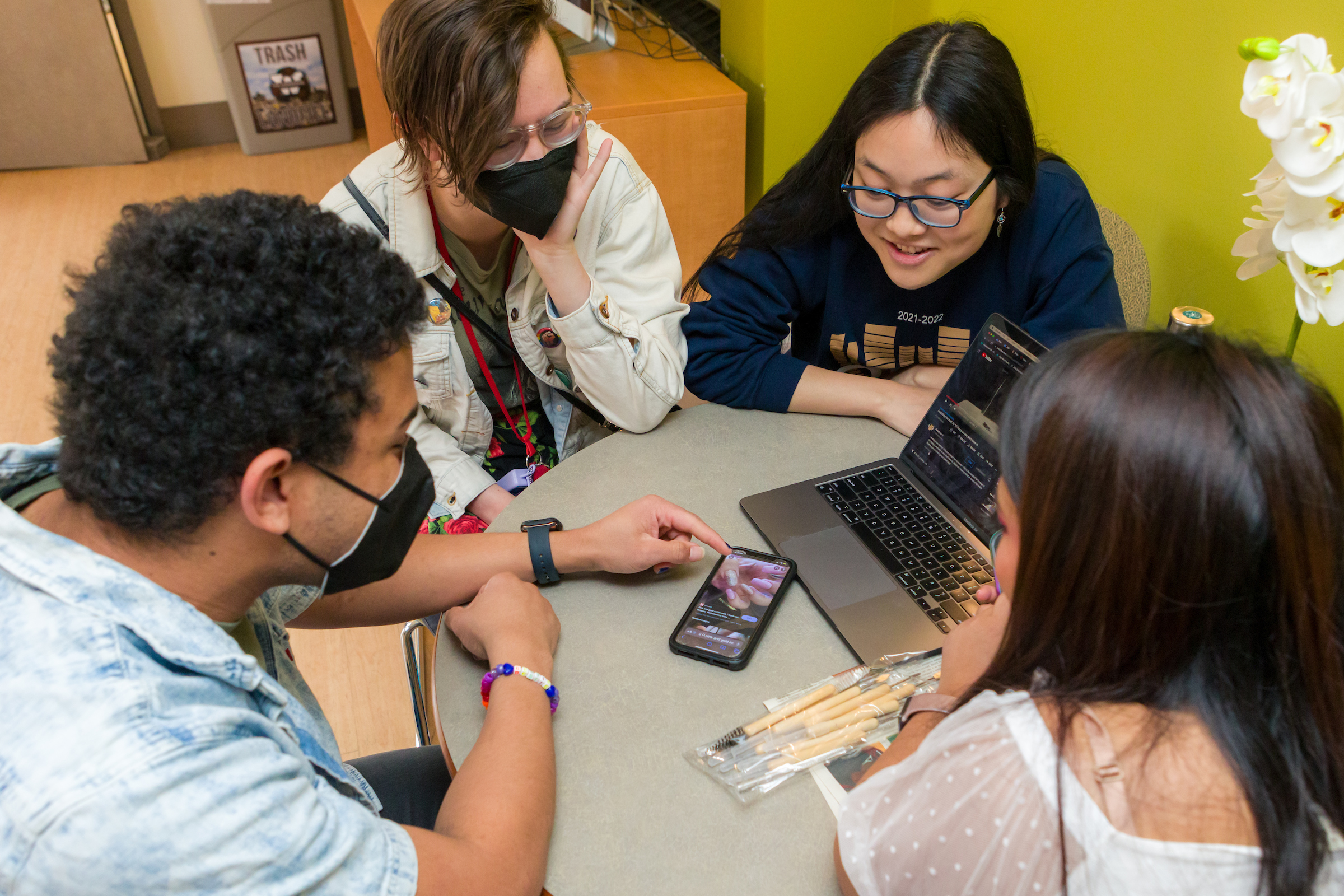 Students looking at a computer in a Merit lounge