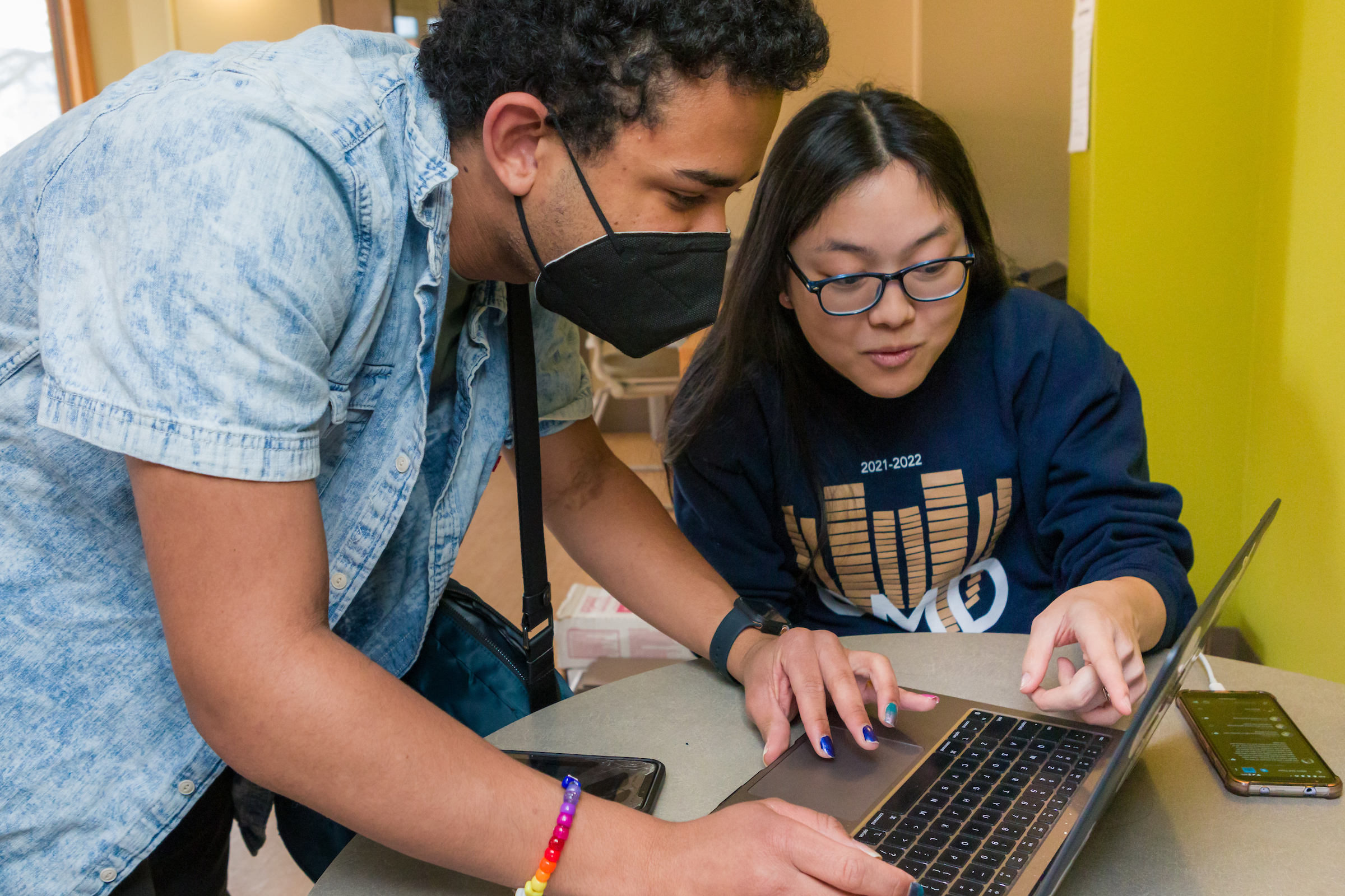 Students looking at a computer in a Merit lounge