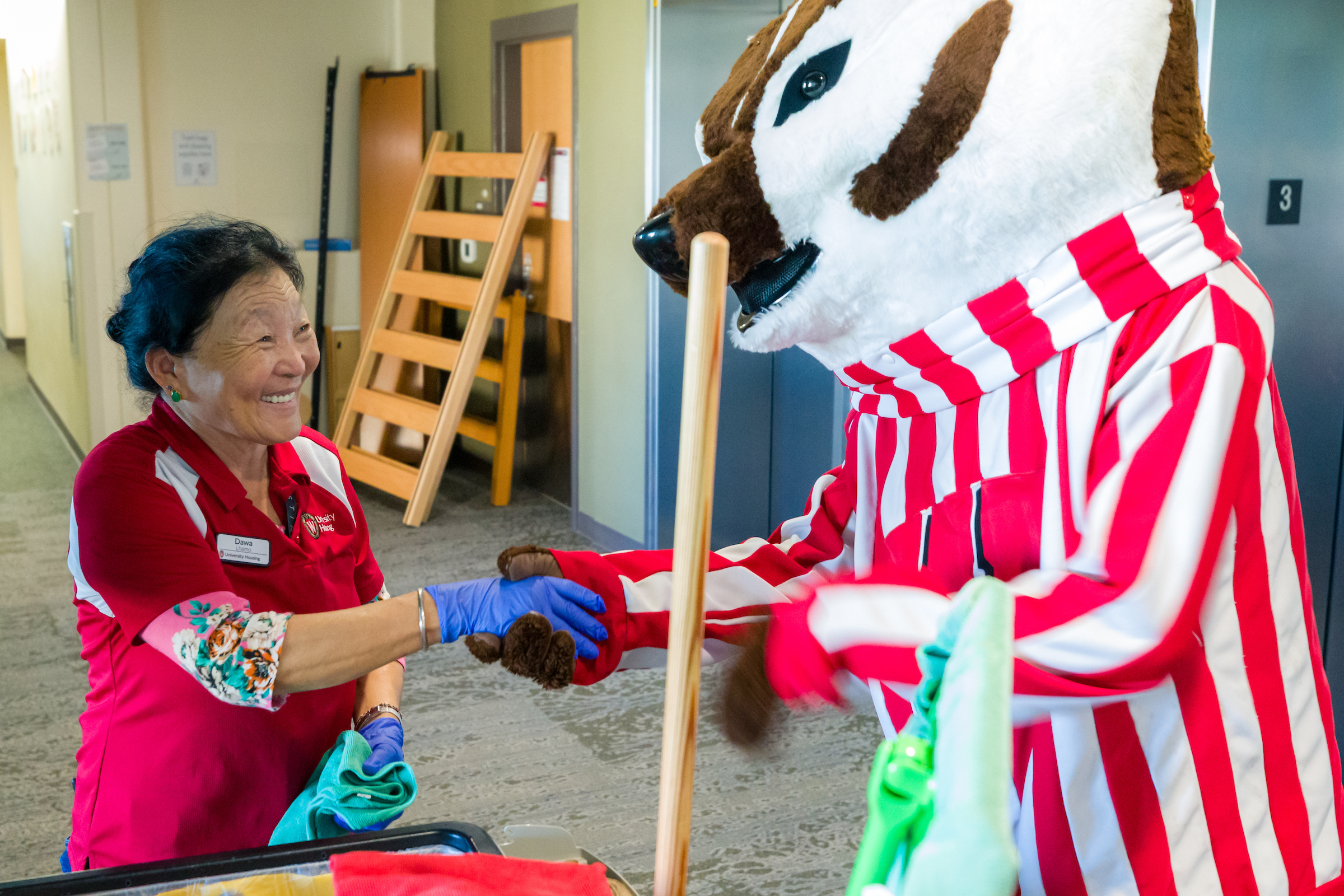 A custodian shaking hands with Bucky Badger