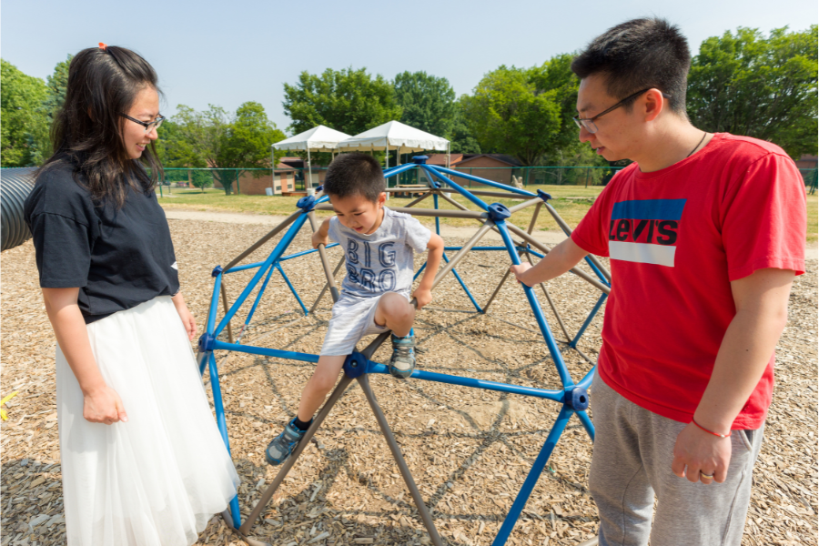 Family hanging out at one of the outdoor play areas around University Apartments.