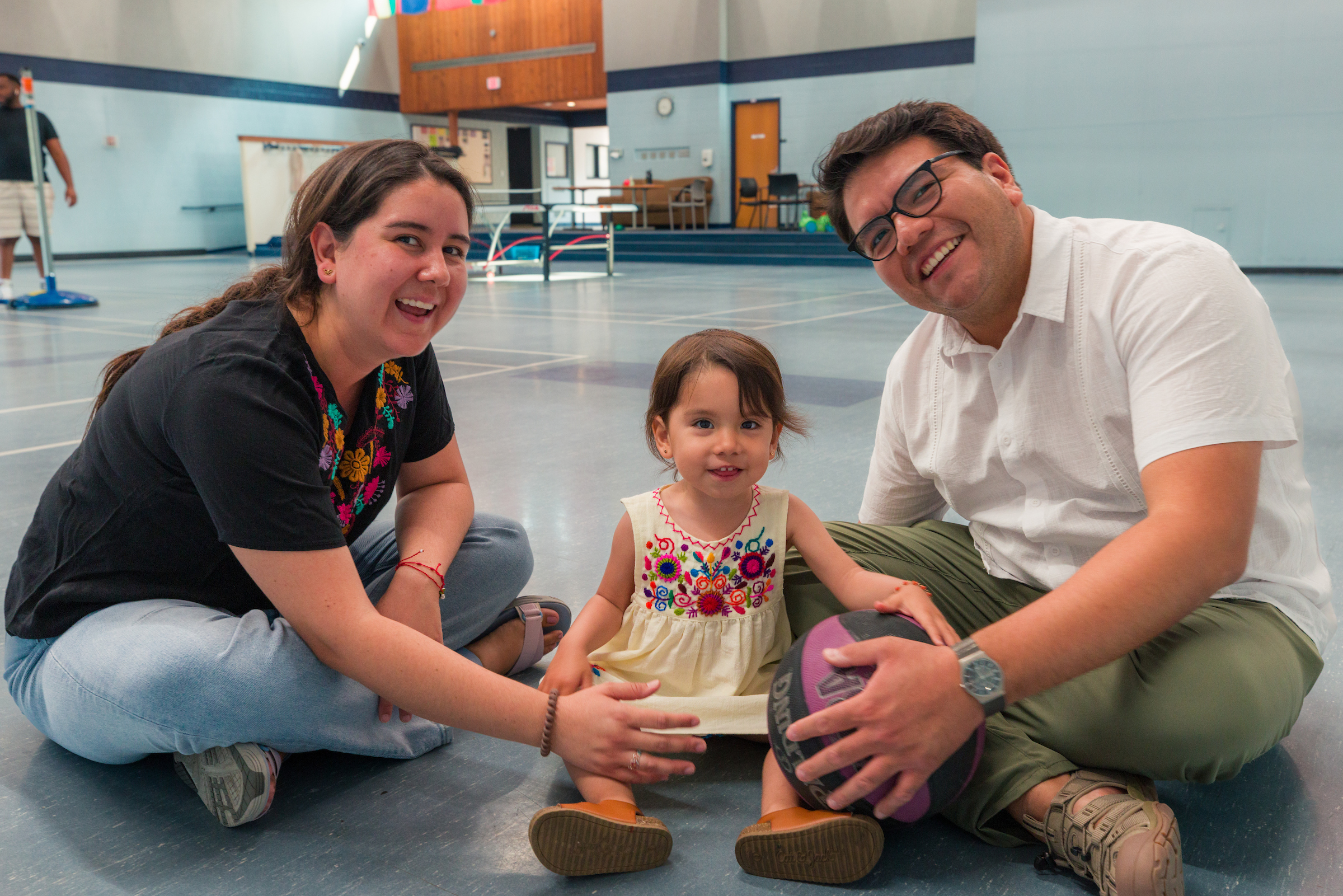 Two adults and a child posing for a photo at the UA Community Center