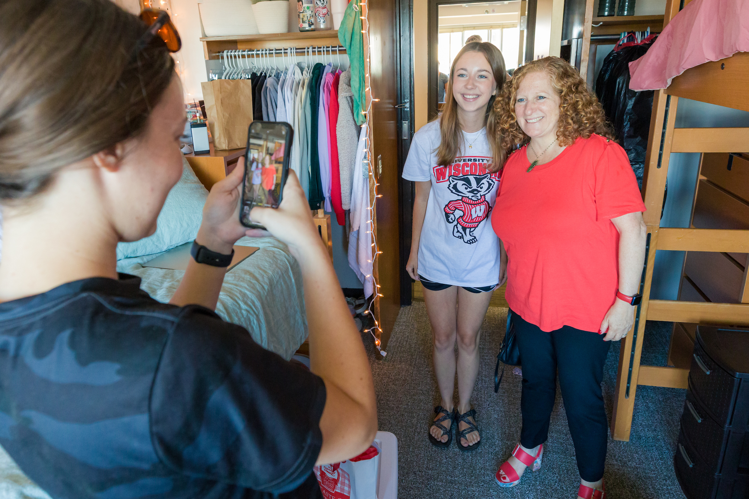 Chancellor Mnookin takes a photo with a new student inside a residence hall room during move-in