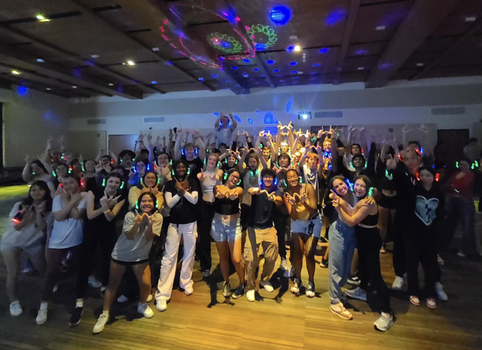 Students posing for a large group photo during a Wisconsin Late Night silent disco event