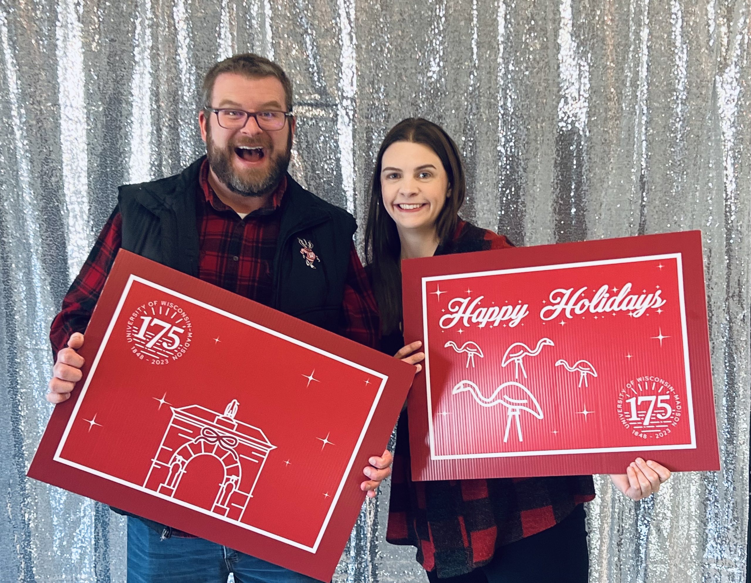 Two Housing staff holding holiday-themed props in a photo booth