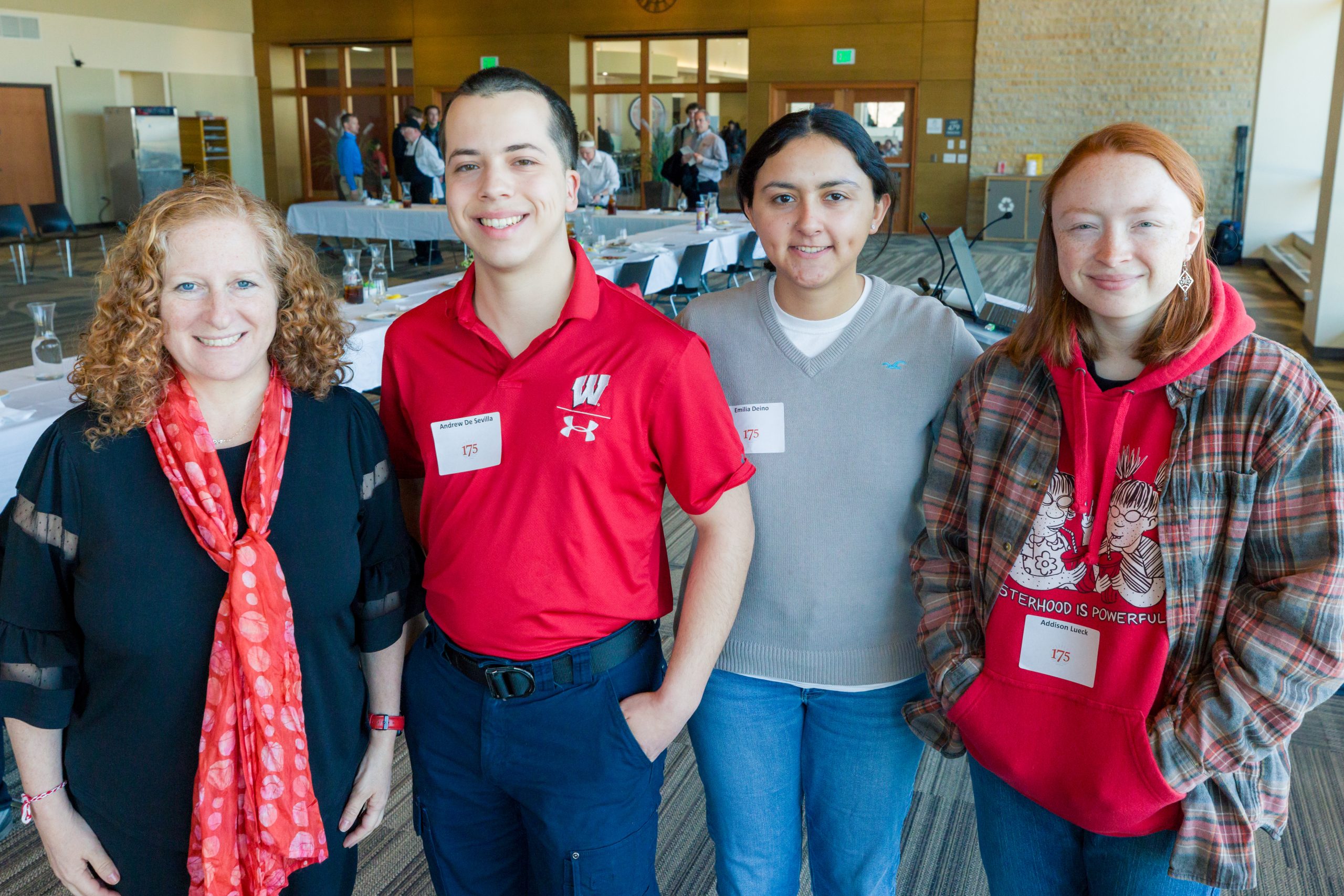 Three students pose for a group photo with Chancellor Mnookin