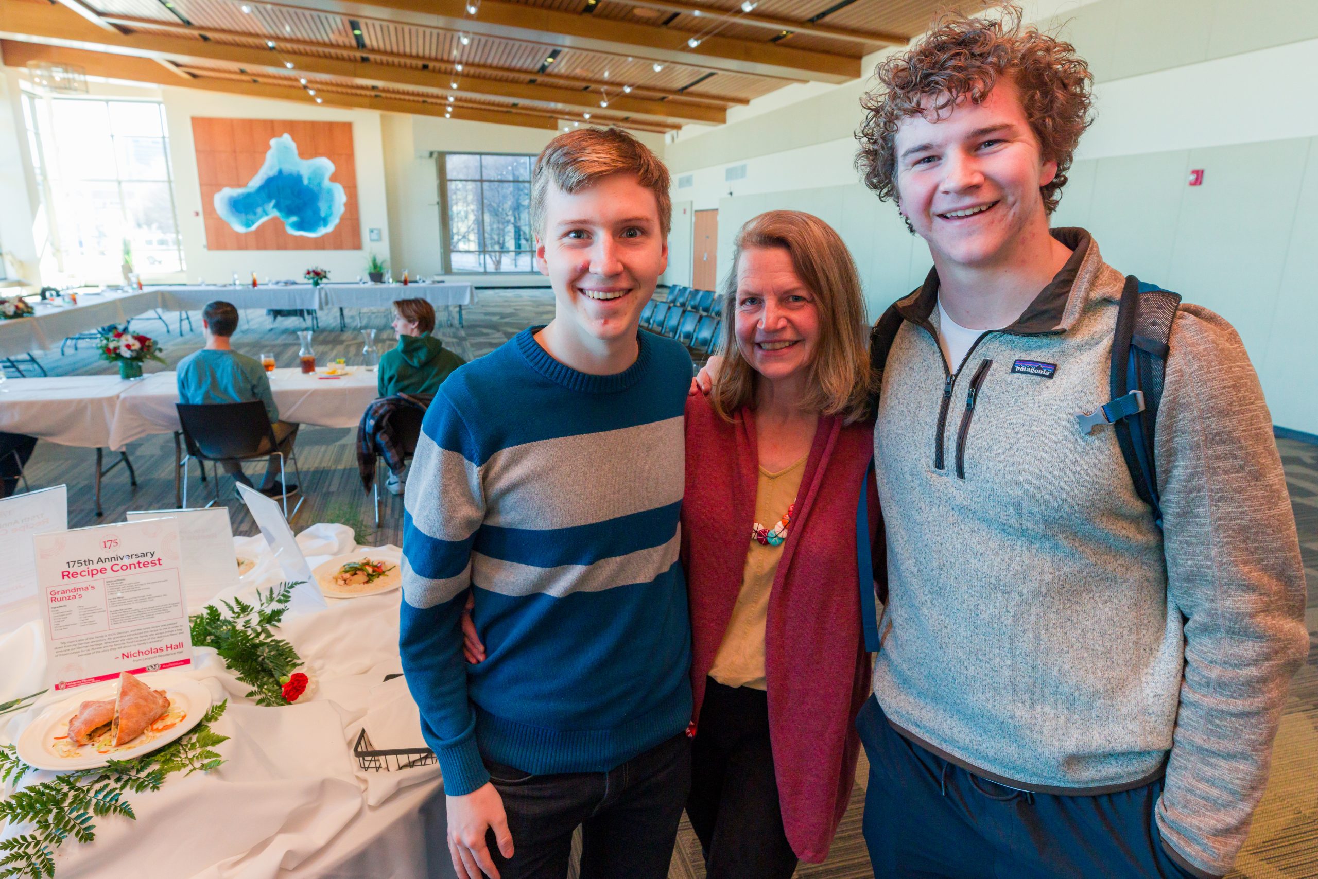 A student poses for a photo with family members in the Lake Mendota Room