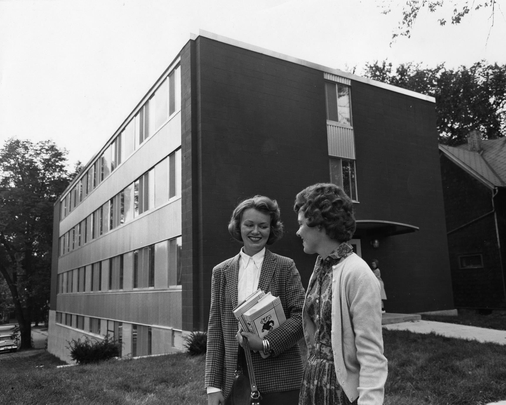 Two people stand outside Davis ca. 1962