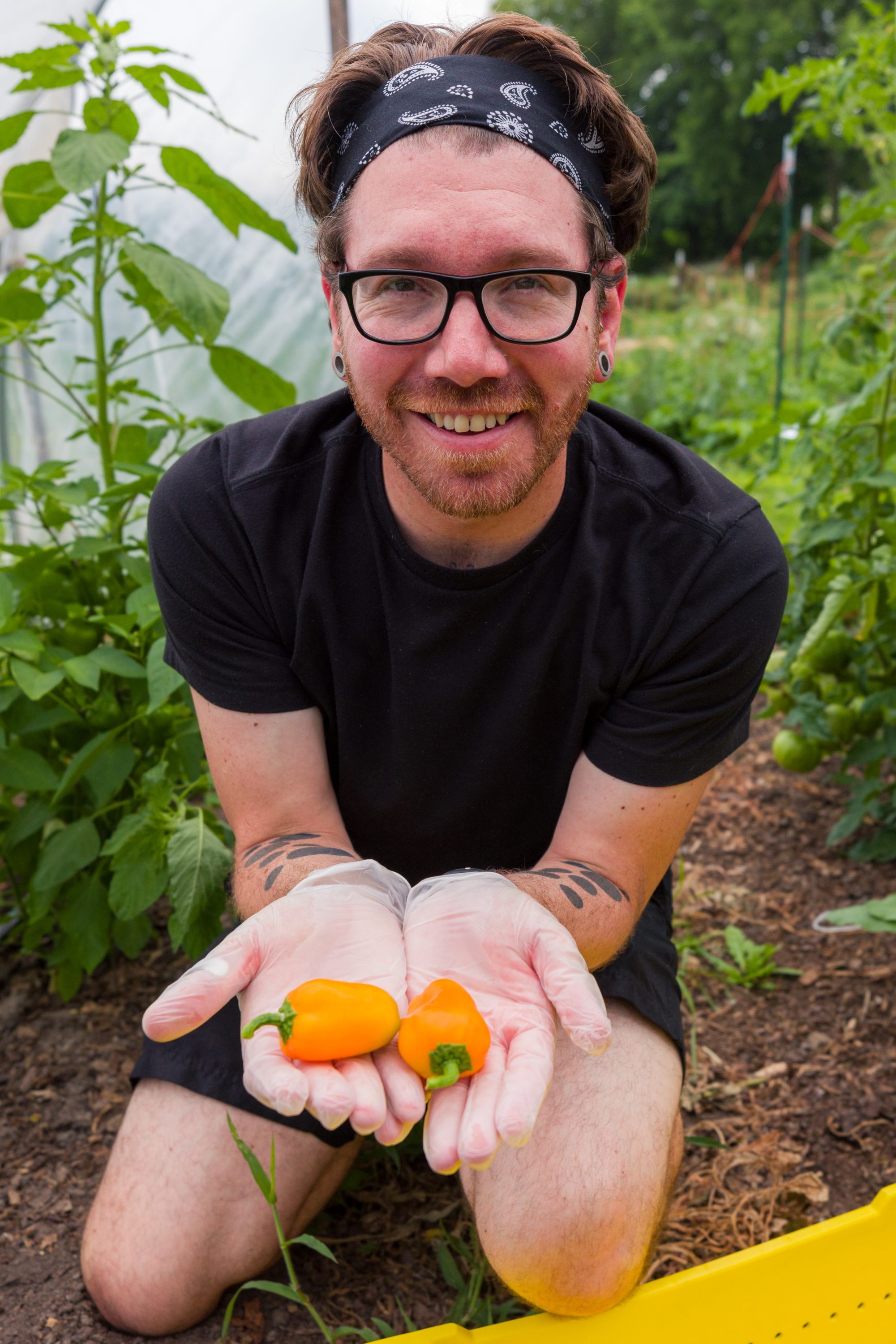 posing for a photo at campus farm with orange peppers