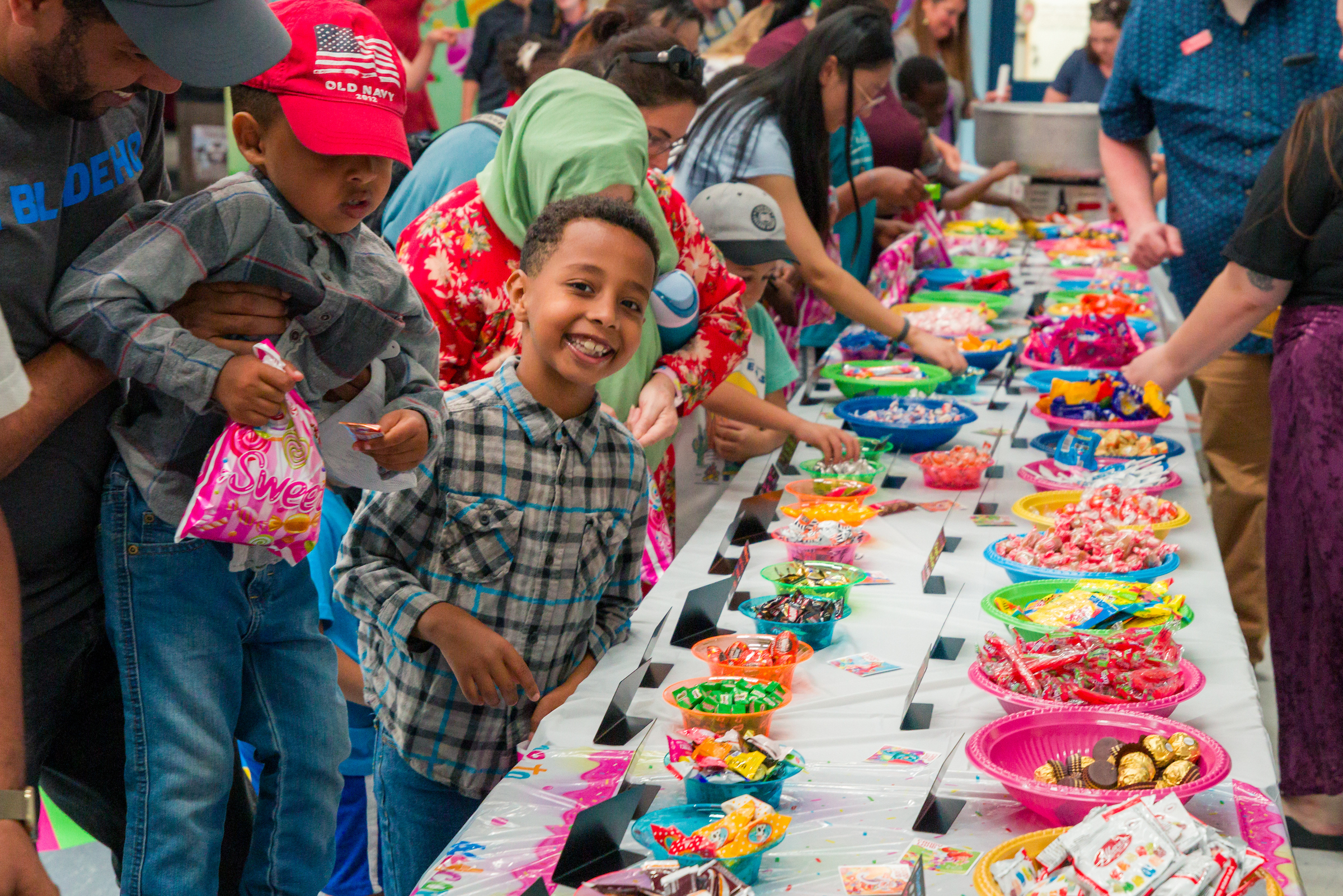 Families picking up candy and a boy smiling at the camera