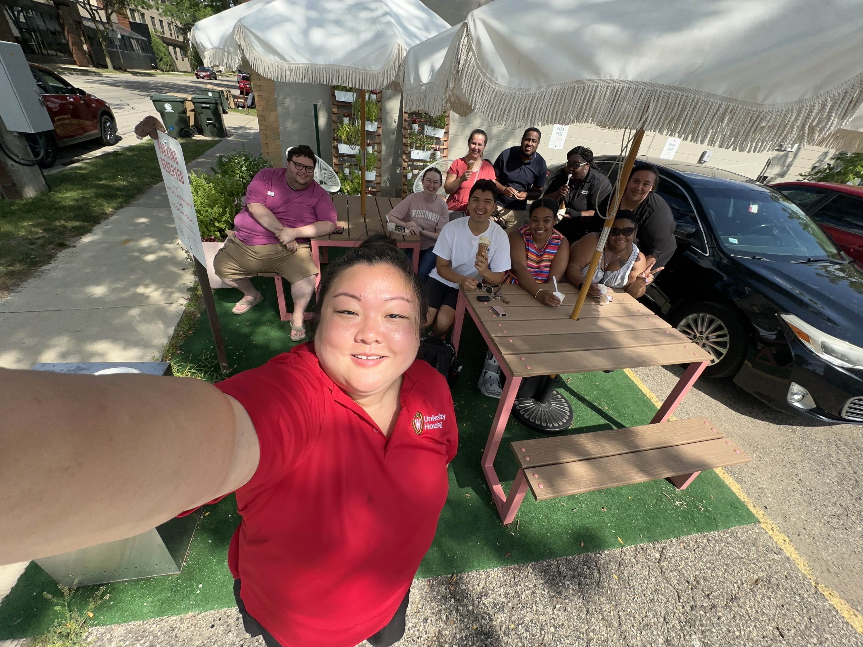 One women taking a selfie with nine others behind her in a photo all smiling