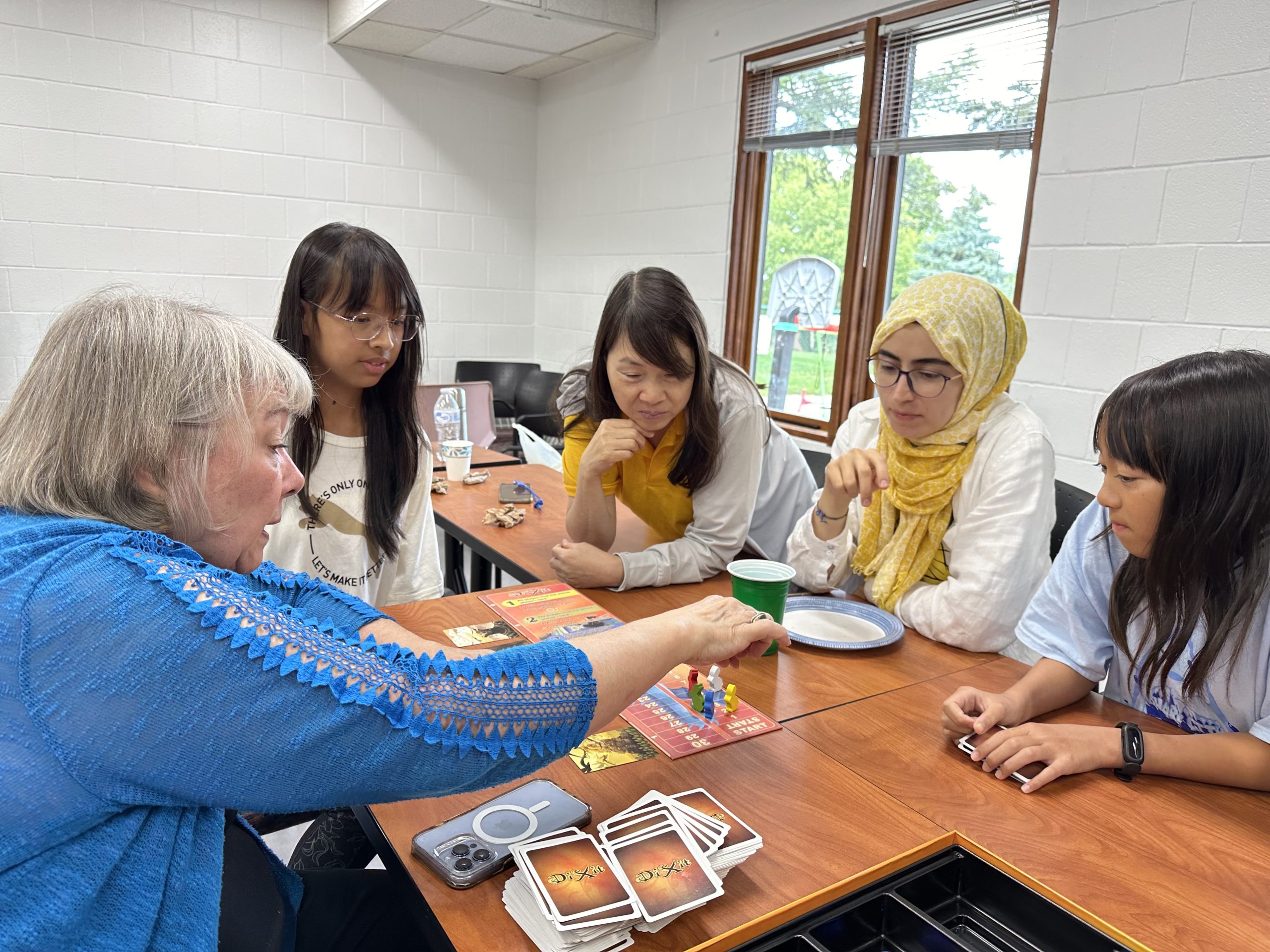 Five women playing a board game
