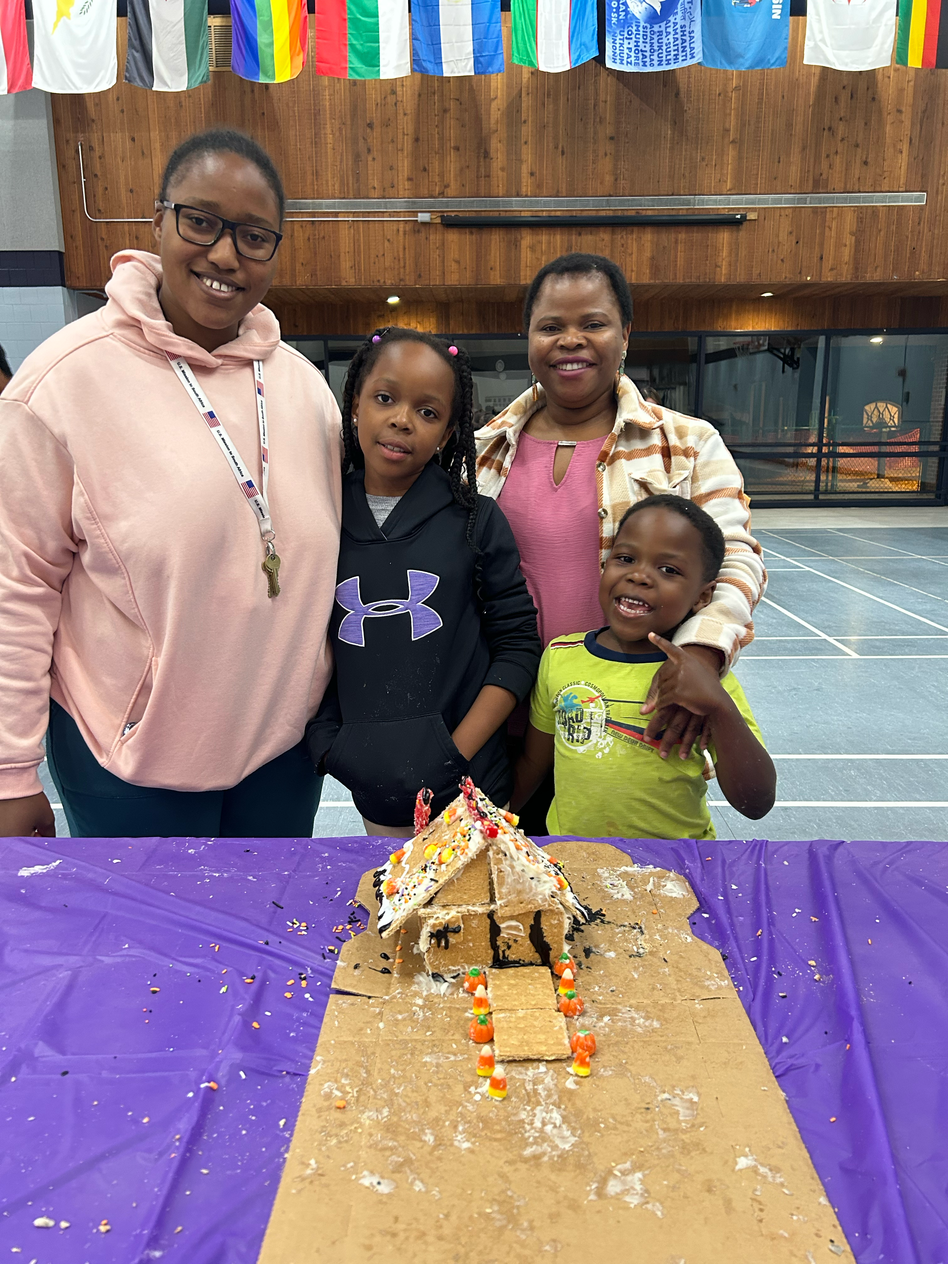 Family of four smiling with haunted house gingerbread