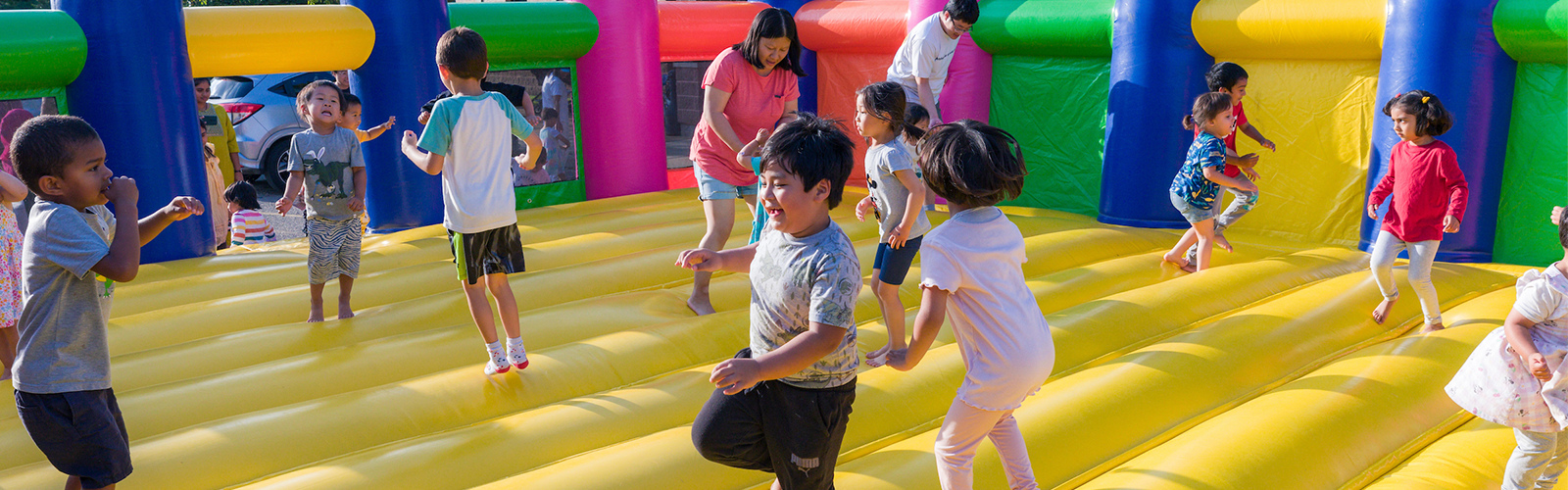 Many little kids jumping in a bounce house.