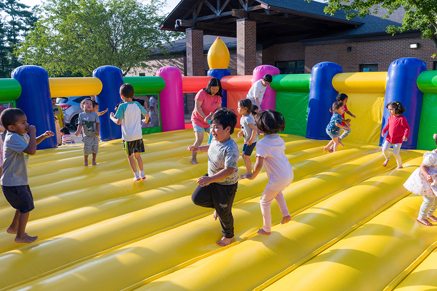 Many little kids jumping around in a bounce house.