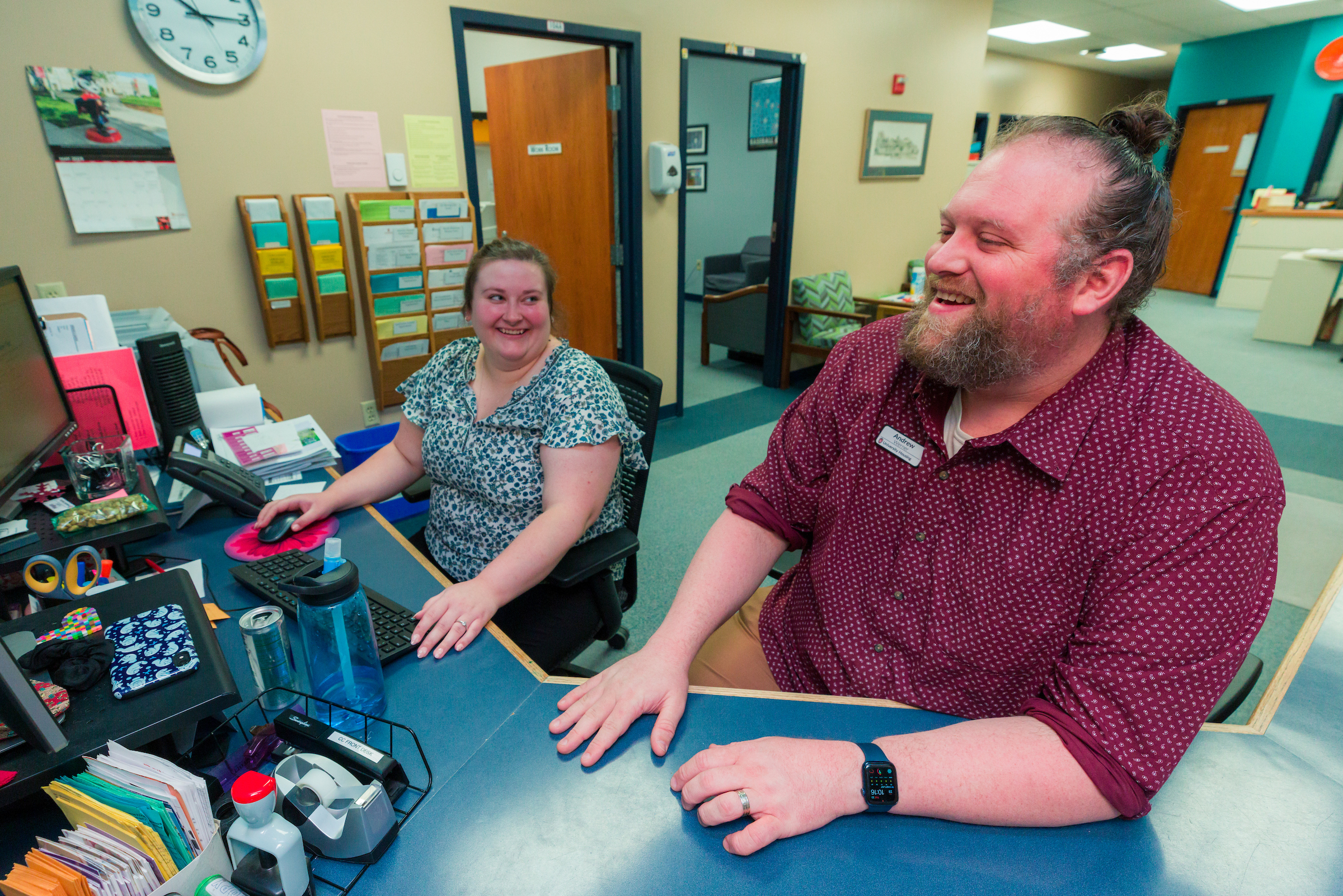 Two people looking at a computer and smiling