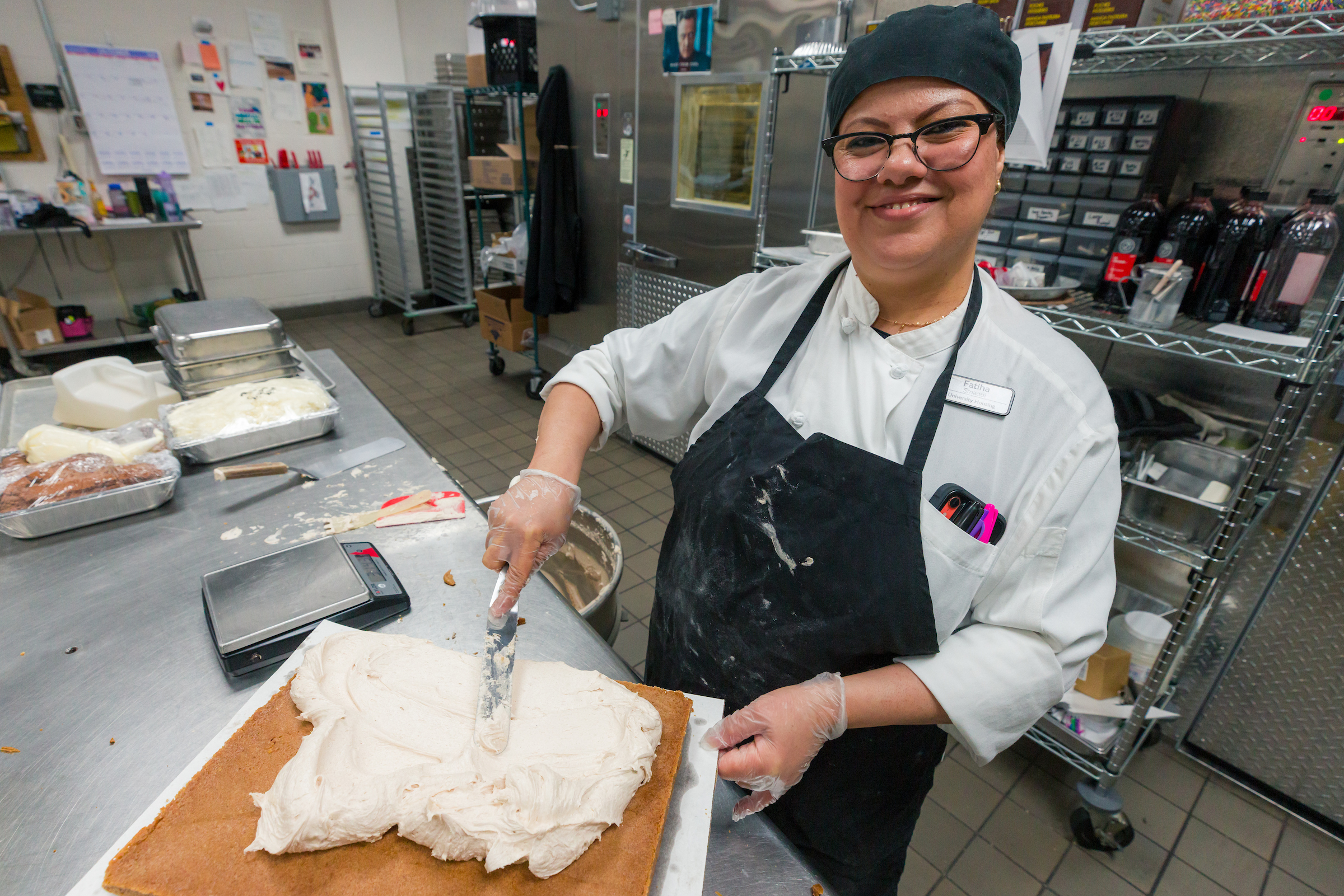 Women smiling at the camera while frosting a cake