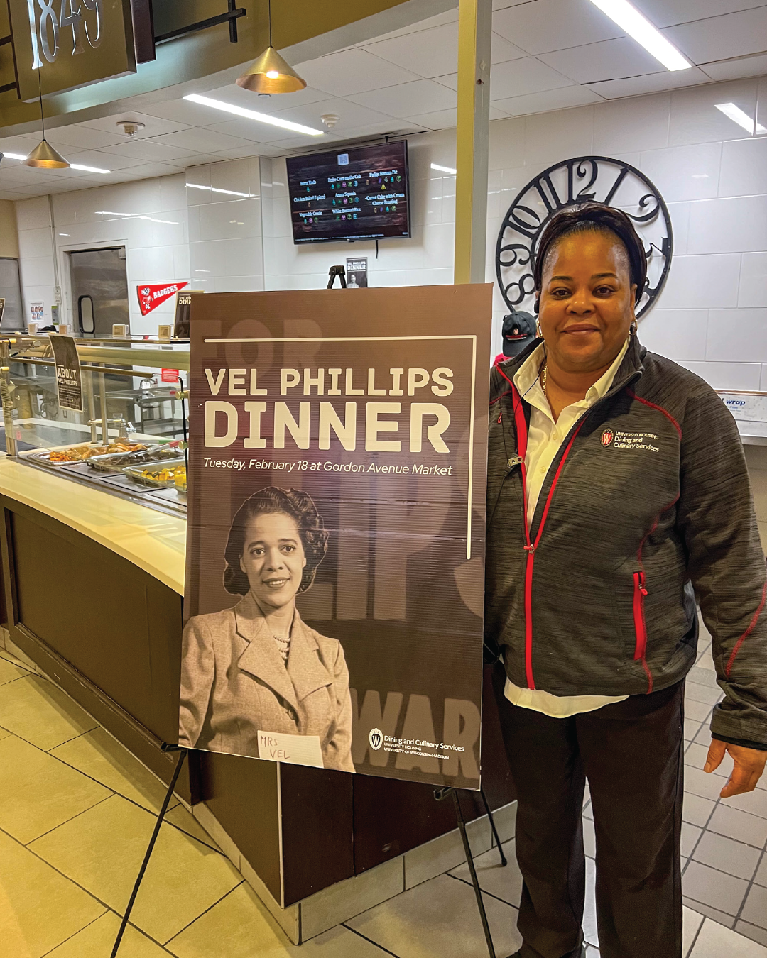 Staff member poses with Vel Phillips sign