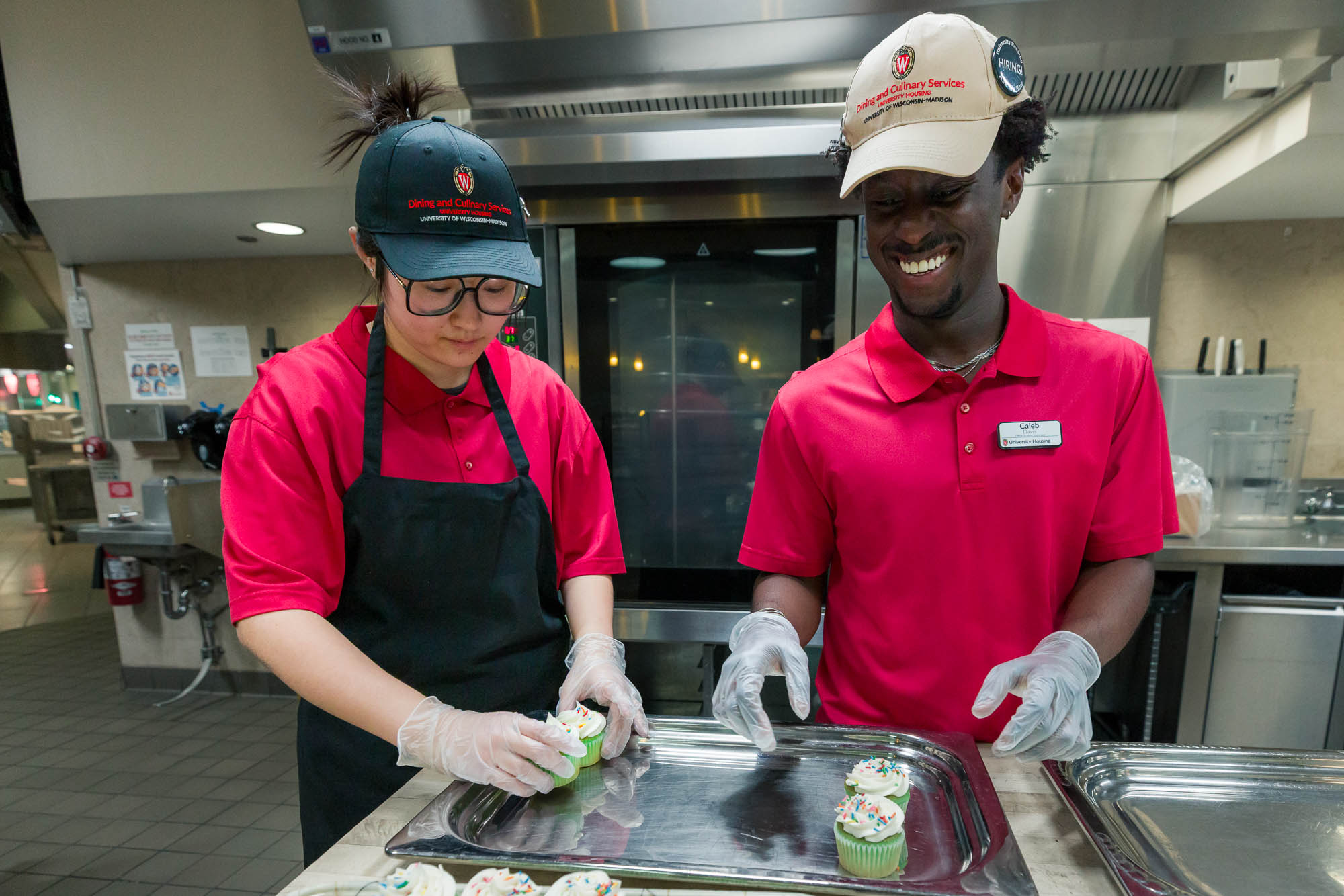 Caleb Davis helps a student employee arrange cupcakes in Gordon Avenue Market.