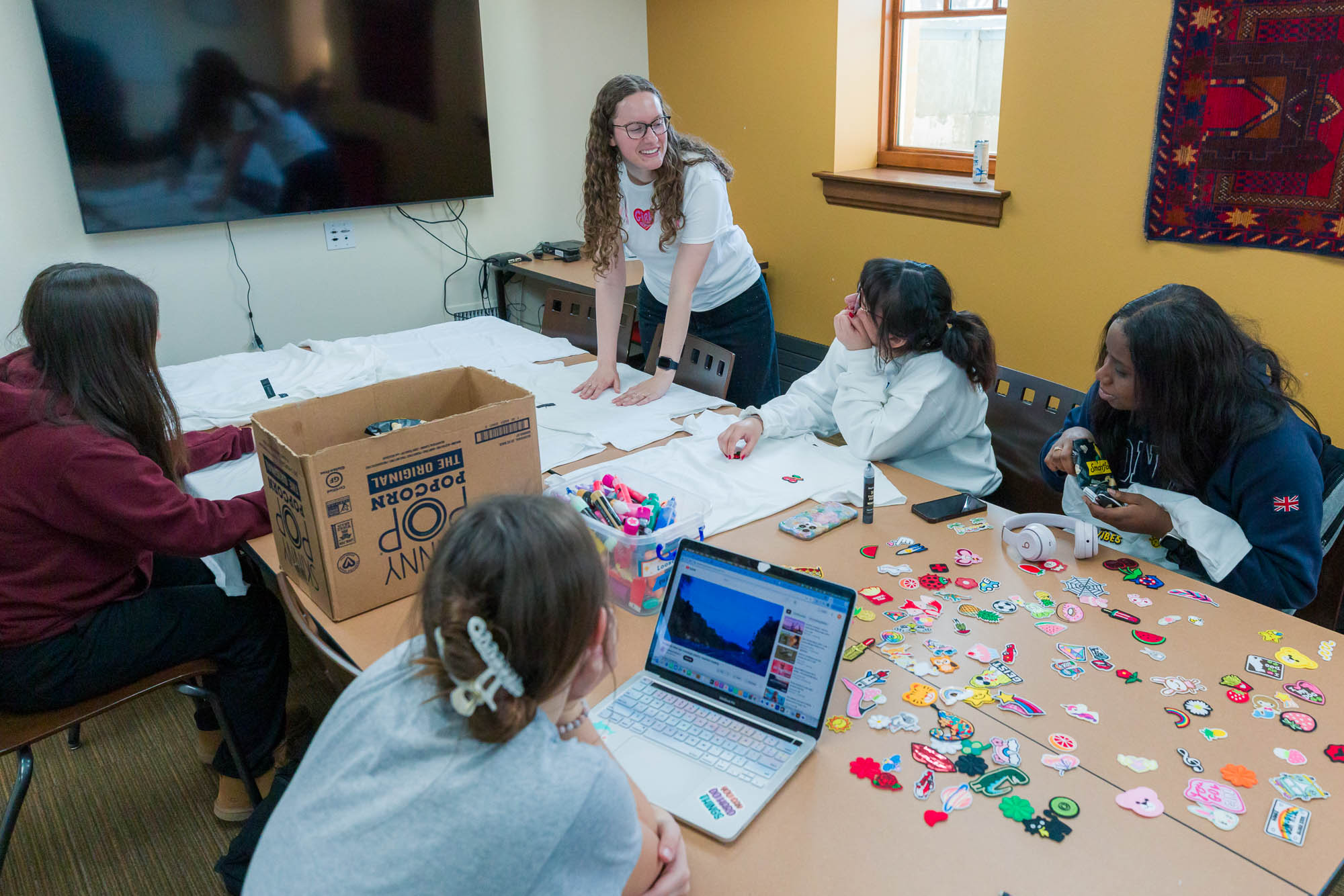 Madison Eiler talks with other student employees in a conference room in Carson Gulley Center during preparations for a Wisconsin Weekday event.