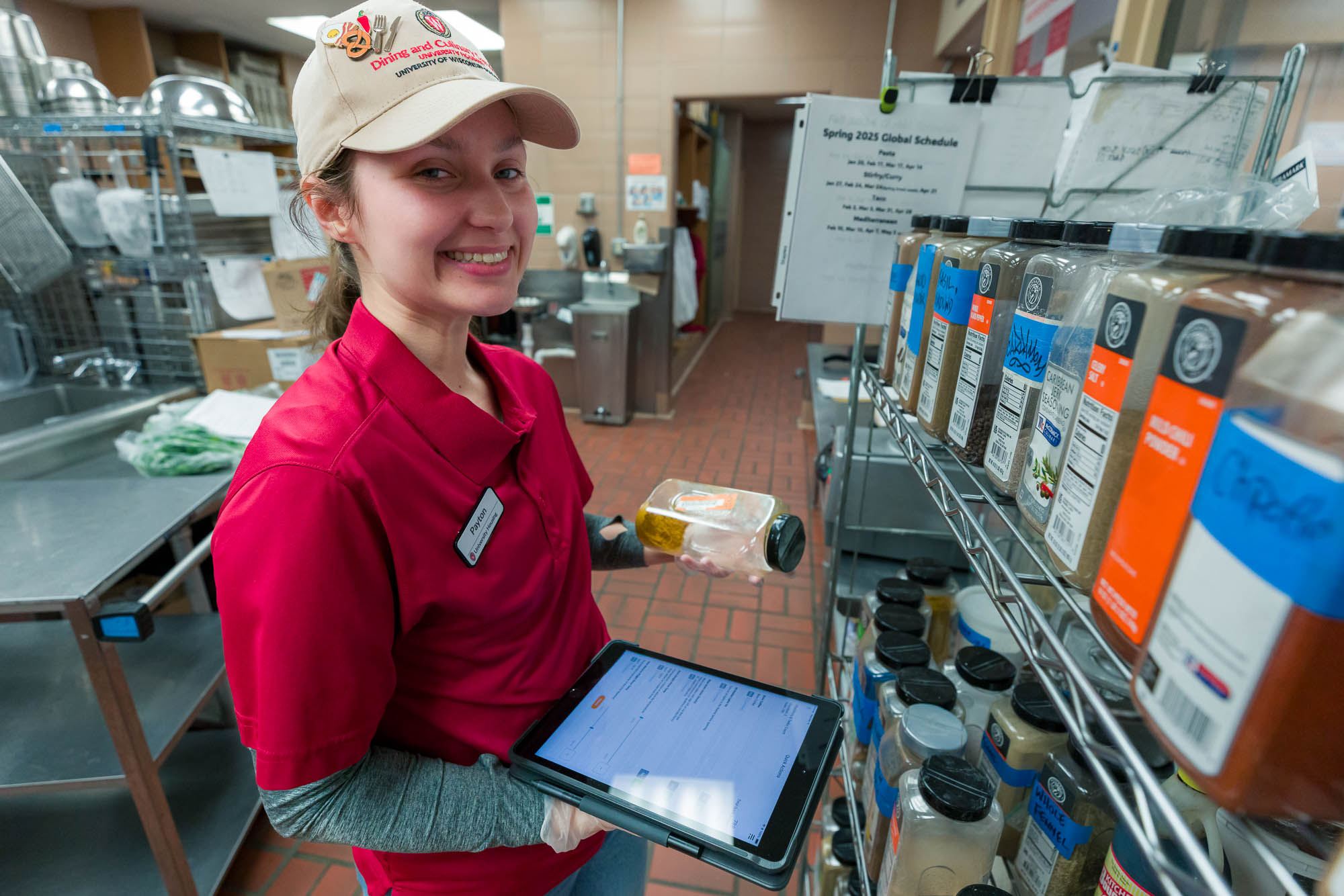 Payton Eilers checks date labels of spices in the kitchen of Lowell Market.
