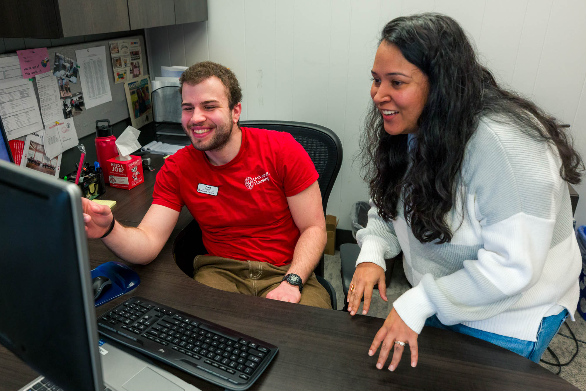 Alex Koory looks at a computer screen with professional staff in the Human Resources Office in Slichter Residence Hall.