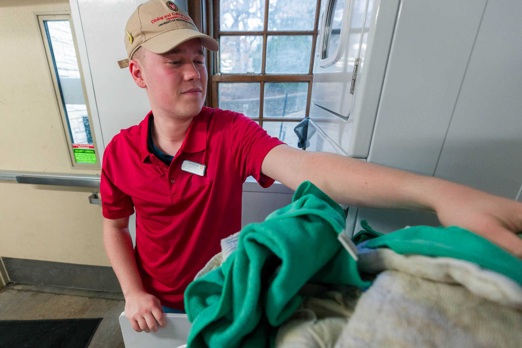 Andrew Mlynsky removes clean linens from a dryer near Liz's Market in Waters Residence Hall.